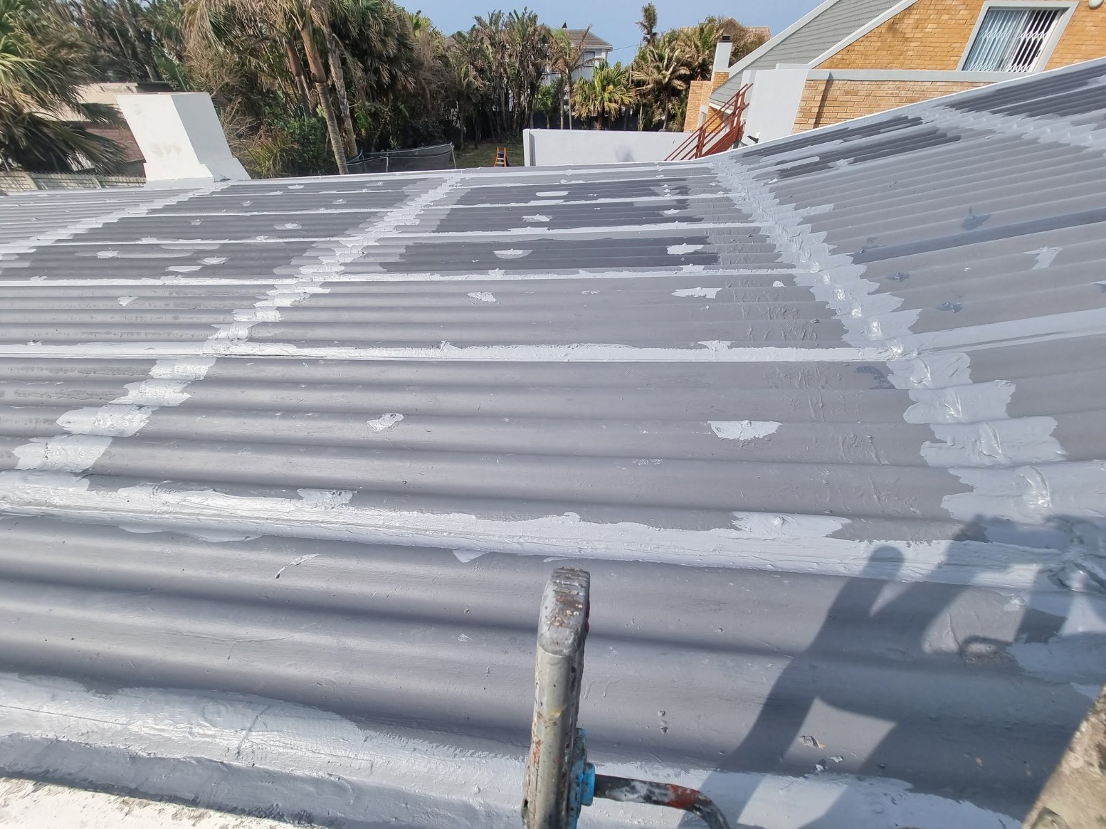 Corrugated roof waterproofing detail with sealed joints and screw points