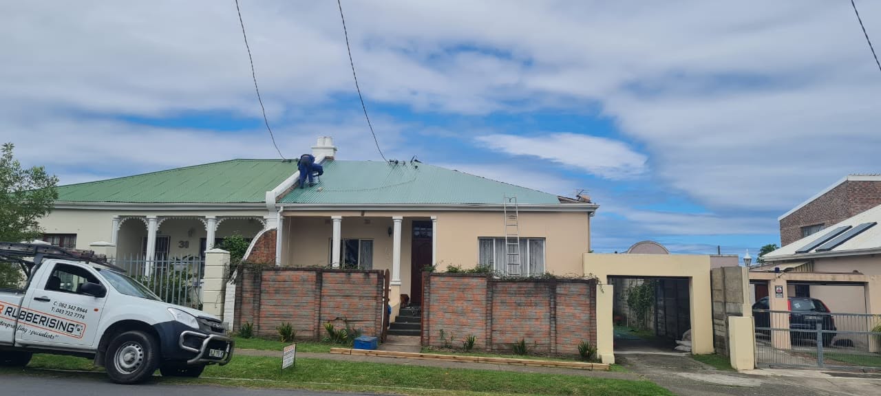 Roof preparation and waterproofing work in progress on residential roof