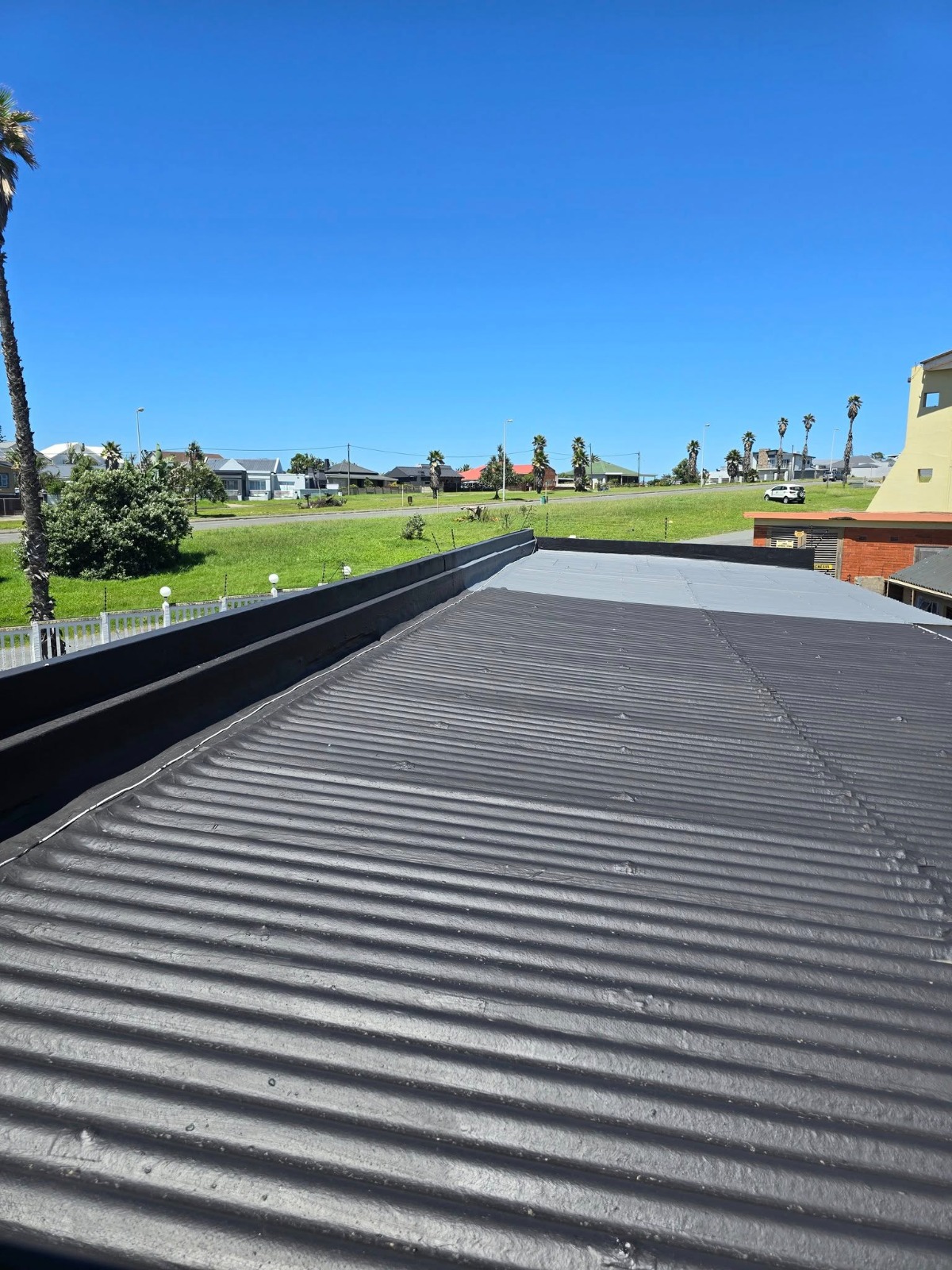 Flat and low-slope roof waterproofed with dark protective liquid rubber coating